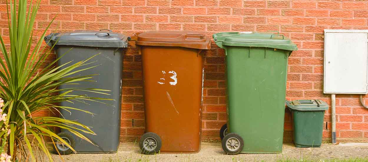 Corby, United Kingdom, 20 june 02019 - traditional wheelie bin in front of a house, brick wall.